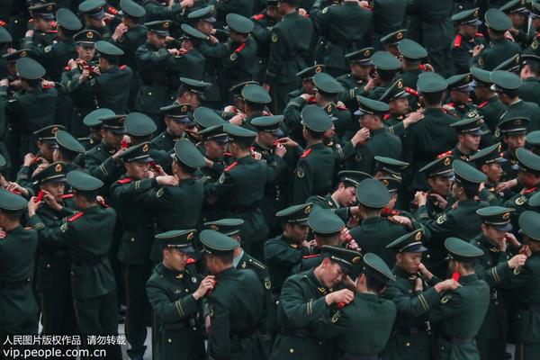 12月12日，武警重庆总队新兵团的新兵们正在互相佩戴肩章。